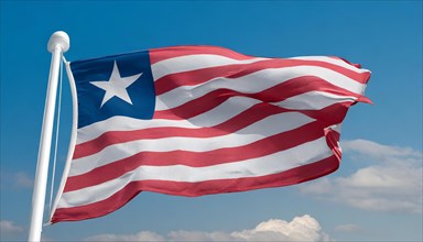 The flag of Liberia, fluttering in the wind, isolated, against the blue sky