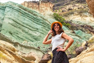 Portrait of a woman at the natural monument at the Azulejos de Veneguera or Rainbow Rocks in Mogan,