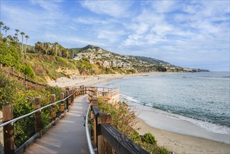 A wooden boardwalk leads to the beach. The beach is a beautiful, serene place with the ocean in the