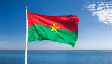 The flag of Burkina Faso flutters in the wind, isolated against the blue sky