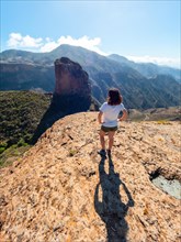 A woman with her back turned at the Roque Palmes viewpoint near Roque Nublo in Gran Canaria, Canary