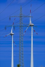 Power pylon with high-voltage lines and wind turbines at the Avacon substation Helmstedt,