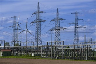 Power pylons with high-voltage lines and wind turbines at the Avacon substation in Helmstedt,