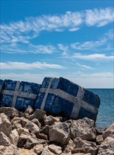 Greece flag painted on the rocks on the sea shore