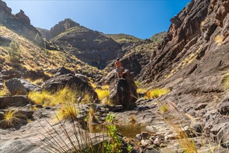A hiker on the river on the climb to Charco Azul in the Podemos to Agaete in Gran Canaria, Canary