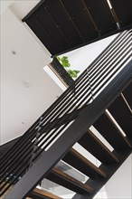 American walnut wood and black powder coated cold rolled steel stairs inside a modern cube style