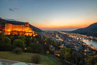 View over an old town with castle or palace rune in the evening at sunset. This town lies in a
