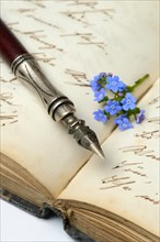 Pen and flower on diary, forget-me-not