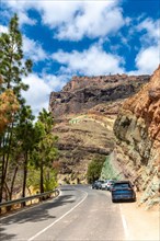 Beautiful road under the natural monument at the Azulejos de Veneguera or Rainbow Rocks in Mogan,
