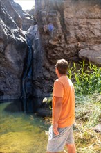 A man looking at the waterfall at Charco Azul in El Podemos a Agaete on Gran Canaria, Canary