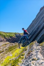 A male hiker visiting the Flysch Basque Coast geopark in Zumaia without people, Gipuzkoa