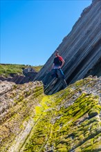A tourist hiker visiting the Flysch Basque Coast geopark in Zumaia, Gipuzkoa