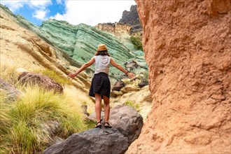 A tourist woman enjoying the natural monument at the Azulejos de Veneguera or Rainbow Rocks in