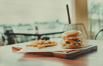 Traditional hamburger with fries served on a restaurant table. Appetizing burger with fries served