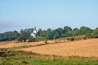 View at a rural landscape view with fields and a church in the swedish countryside, Sloeta,