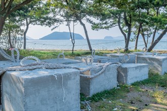 Concrete pier anchors sitting in shade with ocean in background in South Korea