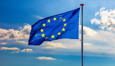 The flag of the EU flutters in the wind, isolated, against the blue sky