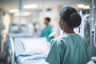 Back view of black nurse with empty hospital bed in background. KI generiert, generiert, AI
