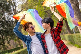 A multi-ethnic gay couple celebrating diversity and love in a park