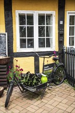 Old bicycle for goods transport at a window in a half-timbered house in Svaneke on the island of