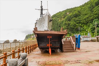 Aft and rudder of wooden boat and exterior of South Korean battleship on display in Unification