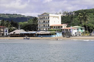 San Juan del Sur, Nicaragua, A view of the shore with a multi-storey building next to palm trees