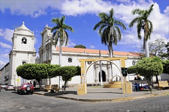 Leon, Nicaragua, A large church with two towers, surrounded by palm trees under a blue sky, Central