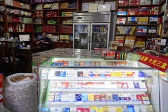 Shanghai, China, Asia, A view into a small shop with a large selection of cigarettes and a smiling