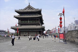 Xian, Shaanxi Province, China, People walk past an old decorative tower under a clear sky, Xian,