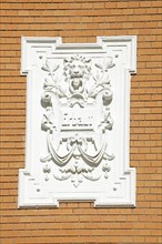 White, decorated plaque on a brick wall of an old Bremen house from the Wilhelminian era, Bremen,