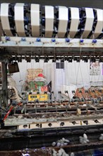 Silk factory Shanghai, close-up of a weaving machine with stripe pattern in a textile factory,