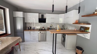 Interior of new modern kitchen with white marble and beige walls