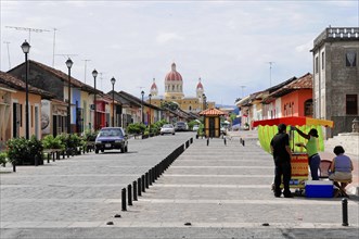 Granada, Nicaragua, View of a busy street running towards a yellow domed cathedral, Central