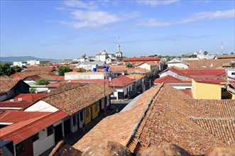Leon, Nicaragua, View over the red tiled roofs of a town with church towers in the background under