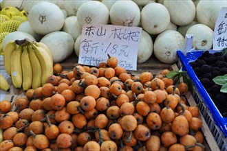 Shanghai, China, Asia, Various fruits such as persimmons, bananas and melons with price tags at a