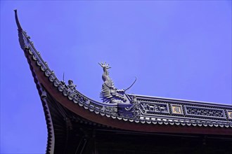 Jade Buddha Temple, Shanghai, detailed view of a temple roof with a dragon sculpture against a blue