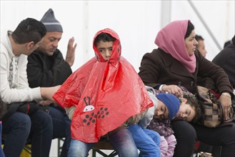A Syrian refugee family and their children wait in a tent at the Berlin State Office for Health and