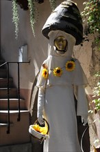 Eguisheim, Alsace, France, Europe, A statue of a woman in a white robe, decorated with sunflowers,