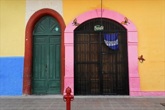 Granada, Nicaragua, The vividly colourful facade of a building with a large wooden door and