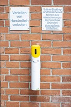 Distribution of flyers prohibited, warning sign on a brick wall on an architectural building in the