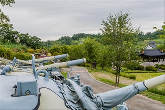 Side view of gun barrels on camouflaged military tanks on display in public park in Nonsan, South