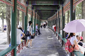 New Summer Palace, Beijing, China, Asia, A group of people walk under a traditionally decorated
