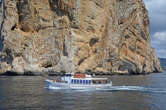 Excursion boat at the rocky coast of Capo Caccia, Alghero, Sassari Province, Sardinia, Italy,