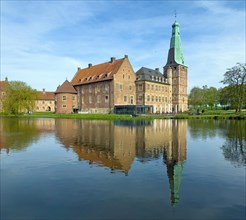 View over moat to historic moated castle from Renaissance Raesfeld Castle reflected in moat in