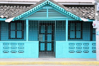 San Juan del Sur, Nicaragua, Turquoise coloured Caribbean house with closed doors and windows,