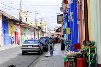 Granada, Nicaragua, View of a busy city street with colourful buildings and various roadside