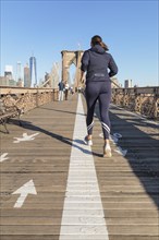 Jogger on the Brooklyn Bridge with Manhattan skyline, New York City, New York, USA, New York City,