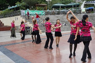 Residents of Chongqing dancing in the centre, Chongqing, China, Asia, People in pink shirts dancing