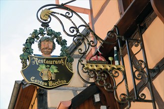 Eguisheim, Alsace, France, Europe, A creative pub sign for the Cadeau Bacchus restaurant with a