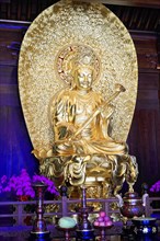 Jade Buddha Temple, Shanghai, Golden Buddha statue in sitting pose, surrounded by religious